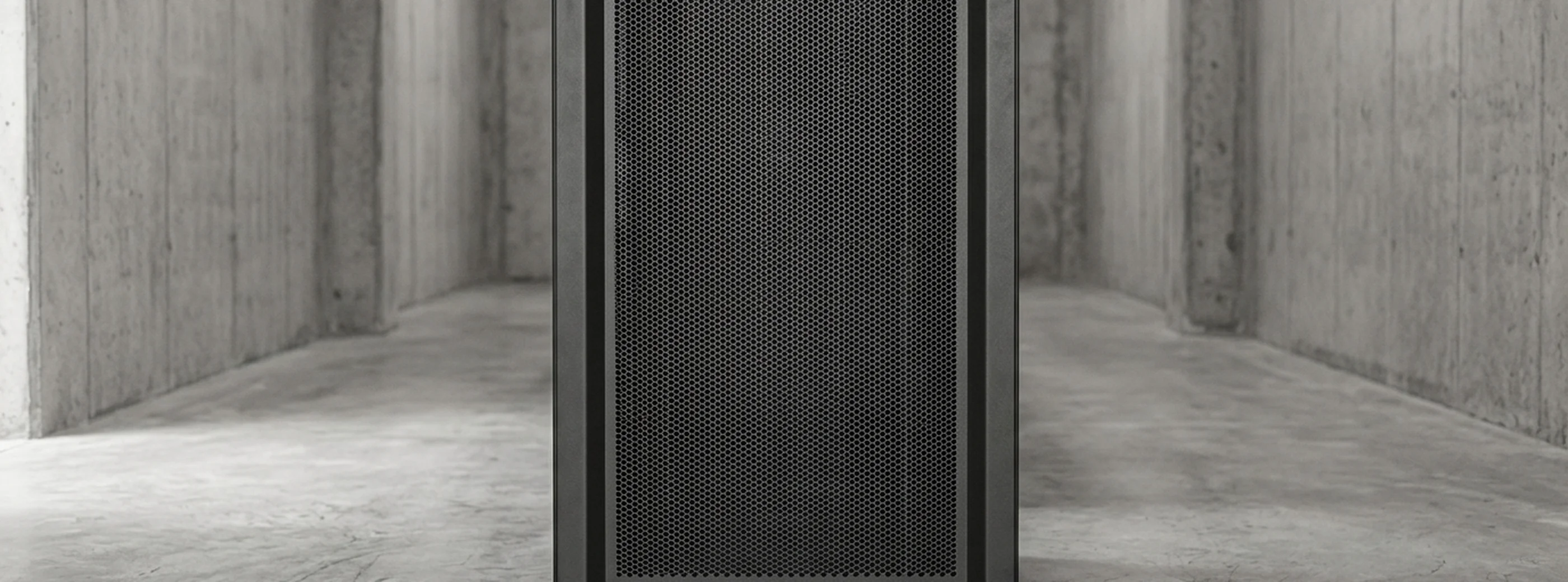 A closed server rack cabinet in a plain concrete corridor.